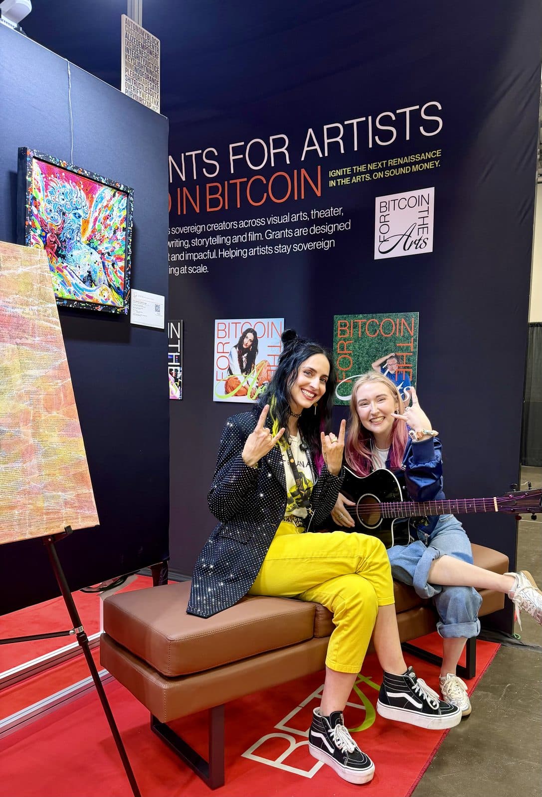 Ainsley Costello and Nadia Vaeh sitting in the Bitcoin Arts Park booth